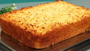 Bolo de aipim com coco dourado e cremoso para servir com café