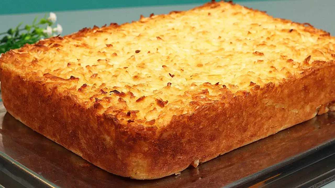 Bolo de aipim com coco dourado e cremoso para servir com café